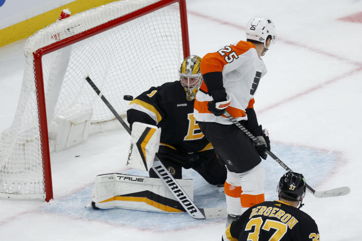 Boston Bruins goaltender Jeremy Swayman (1) makes a save as Philadelphia Flyers left wing James van Riemsdyk (25) looks for a deflection during the first period of an NHL hockey game, Monday, Jan. 16, 2023, in Boston. (AP Photo/Mary Schwalm)