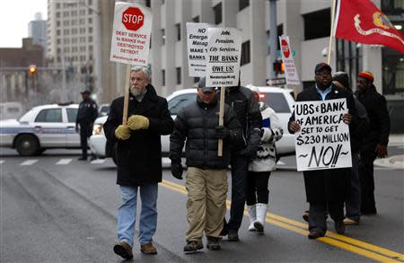 Protesters rally outside the Detroit Federal Court House as Detroit Police block Lafayette Avenue from traffic during a bankruptcy hearing declaring Detroit is eligible for the biggest municipal bankruptcy in U.S. history in Detroit, Michigan December 3, 2013. REUTERS/Rebecca Cook