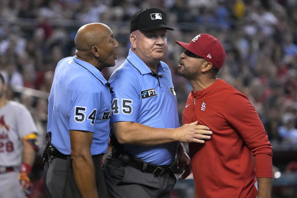 FILE - St. Louis Cardinals manager Oliver Marmol, right, is restrained by umpire Jeff Nelson (45) while talking to C.B. Bucknor (54) during the third inning of the team's baseball game against the Arizona Diamondbacks on Aug. 21, 2022, in Phoenix. Jeff Nelson and Ed Hickox are retiring as umpires and were replaced Monday on the major league staff by Ryan Wills and Clint Vondrak. (AP Photo/Rick Scuteri, File)