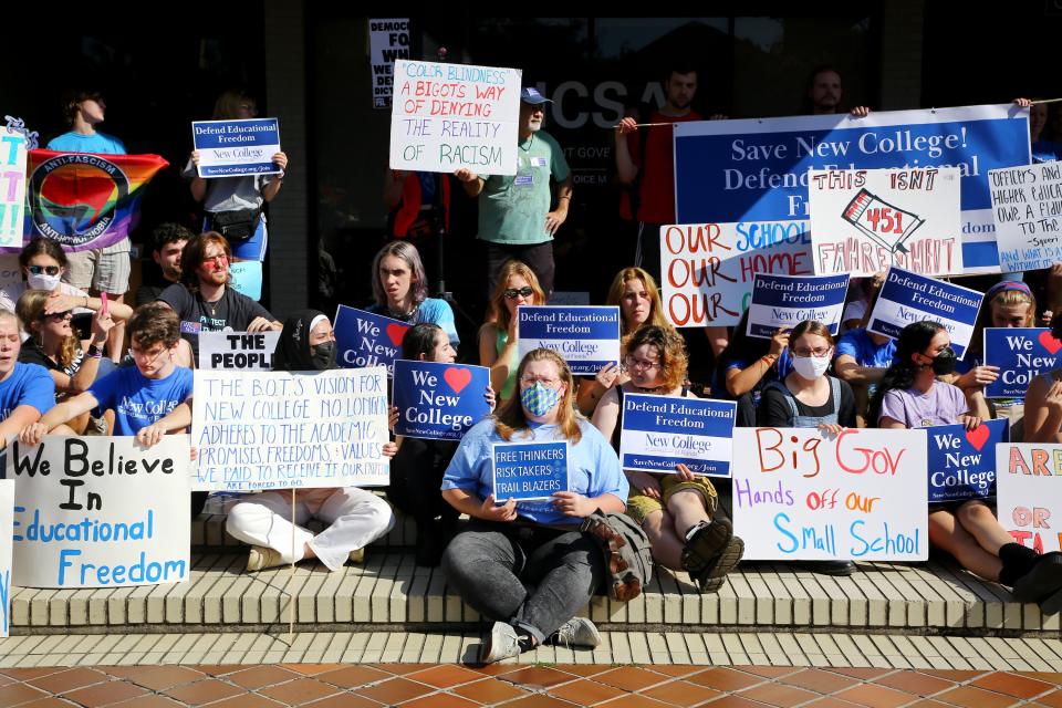 New College students seated on some steps, some in masks, carry placards that say: Bog Gov Hands off our Small School; We Believe in Educational Freedom; This Isn't Fahrenheit  451 and other slogans.