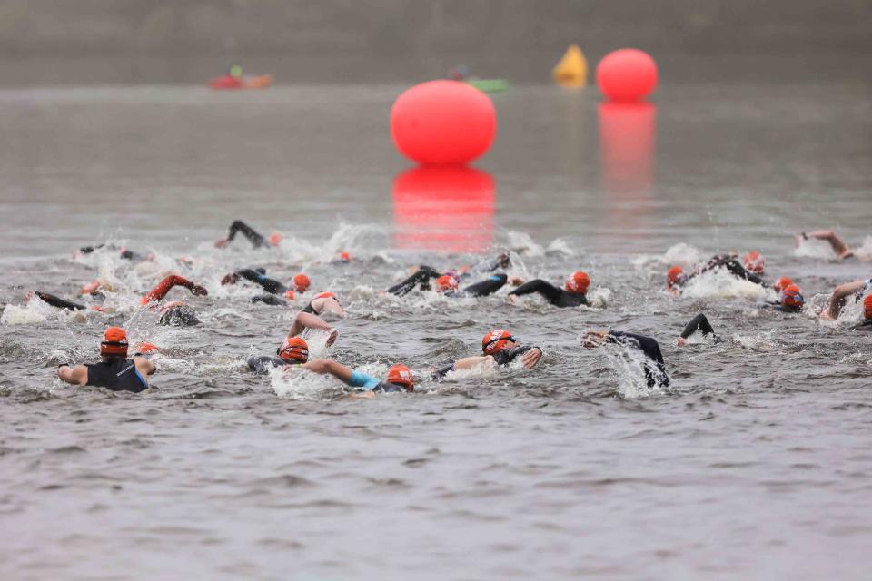 A crowd of swimmers begins competition in the Bear Triathlon on May 15 at Lums Pond State Park.