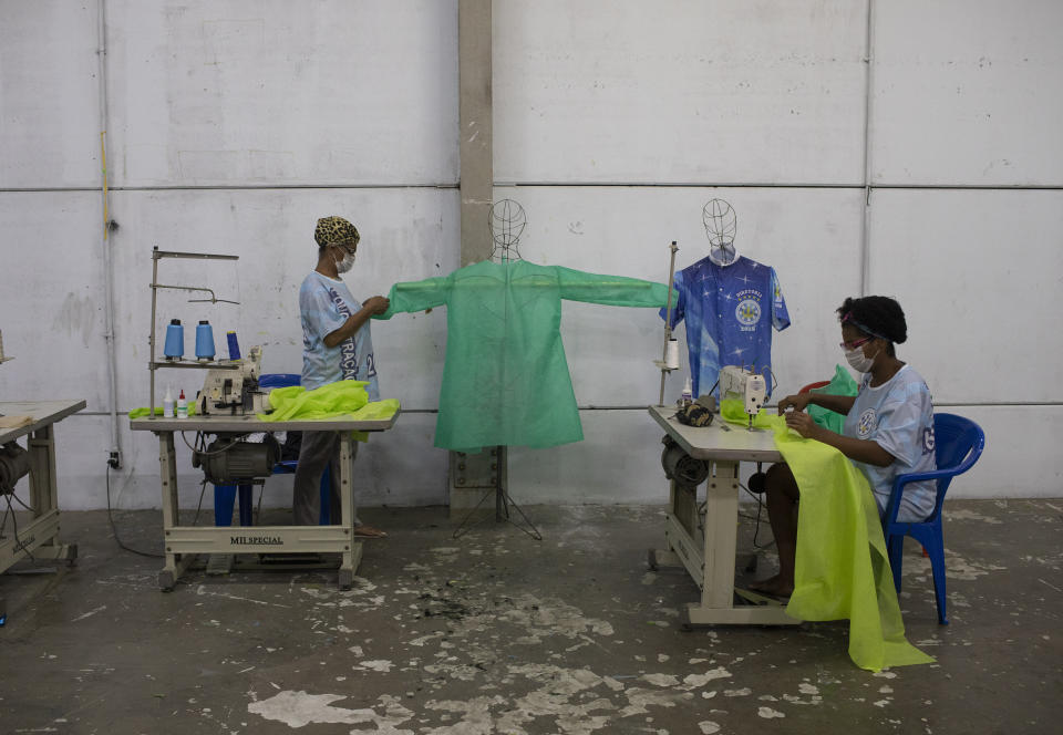 Costureras de las escuela de samba Vila Isabel cosen trajes desechables para trabajadores sanitarios durante la pandemia del coronavirus, en Río de Janeiro, Brasil, el 7 de abril de 2020. Las escuelas de samba de Río de Janeiro suelen pasar el año cosiendo frenéticamente los disfraces para el impresionante Carnaval de la ciudad. Ahora, esos ágiles dedos trabajan para proteger vidas, elaborando trajes de protección para los empleados de salud que enfrentan una oleada de pacientes con coronavirus. (AP Foto/Silvia Izquierdo)