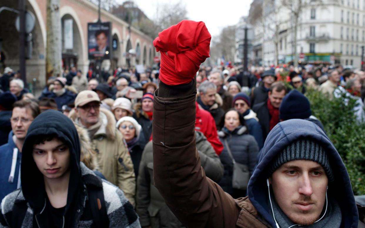 A man with his hand wrapped in a red scarf takes part in a rally in Paris on January 27 - AP