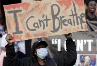 A protester holds a sign as thousands gather at Town Hall in Sydney, Saturday, June 6, 2020, to support the cause of U.S. protests over the death of George Floyd. Black Lives Matter protests across Australia proceeded mostly peacefully as thousands of demonstrators in state capitals honored the memory of Floyd and protested the deaths of indigenous Australians in custody. (AP Photo/Rick Rycroft)