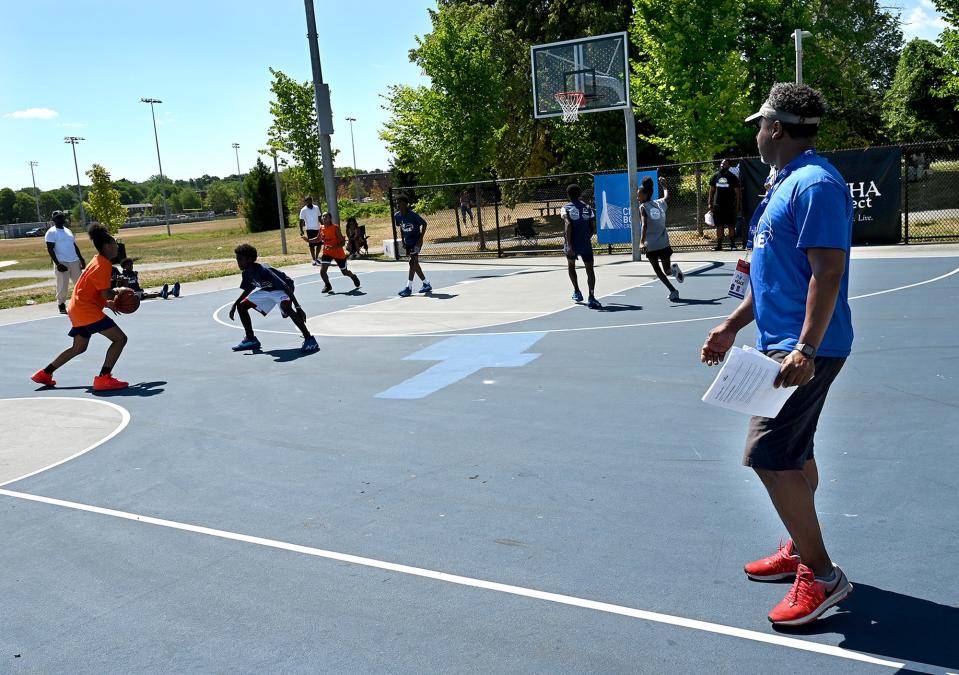 Philip Hillman, a 1988 graduate of Lincoln-Sudbury High School, follows the action during the "Play 4 Peace" 3-on-3 basketball tournament at Harambee Park in Boston, July 30. The second annual event was created by a group of friends from the Lincoln-Sudbury Class of 1988.