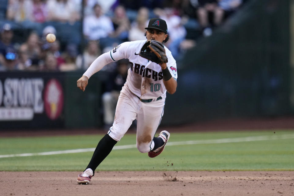 Arizona Diamondbacks third baseman Josh Rojas chases down a grounder hit by Los Angeles Dodgers' Mookie Betts before throwing the ball to first base for the out during the ninth inning of a baseball game Sunday, April 9, 2023, in Phoenix. The Diamondbacks won 11-6. (AP Photo/Ross D. Franklin)