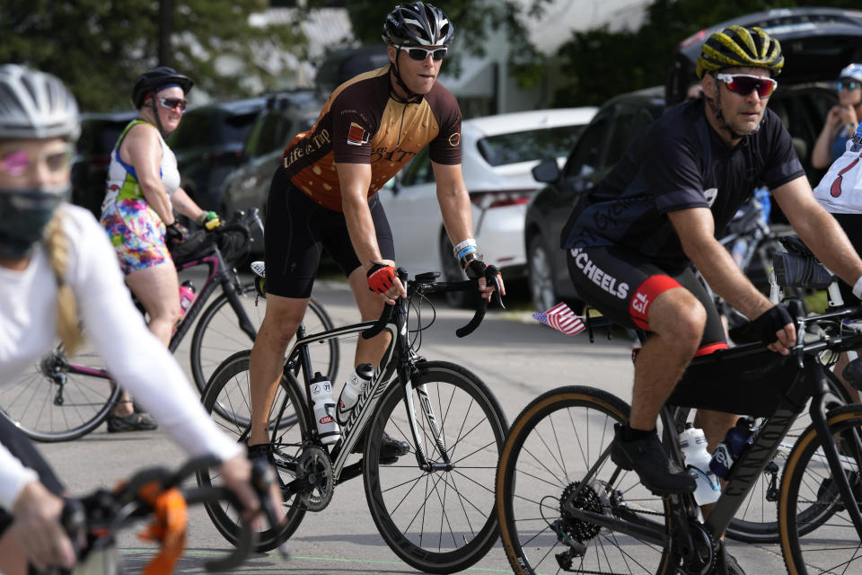 Associated Press reporter Dave Skretta, center, rides into town while riding in The Des Moines Register's annual bike ride across Iowa, also known as RAGBRAI, Tuesday, July 25, 2023, in Rippey, Iowa. (AP Photo/Charlie Neibergall)