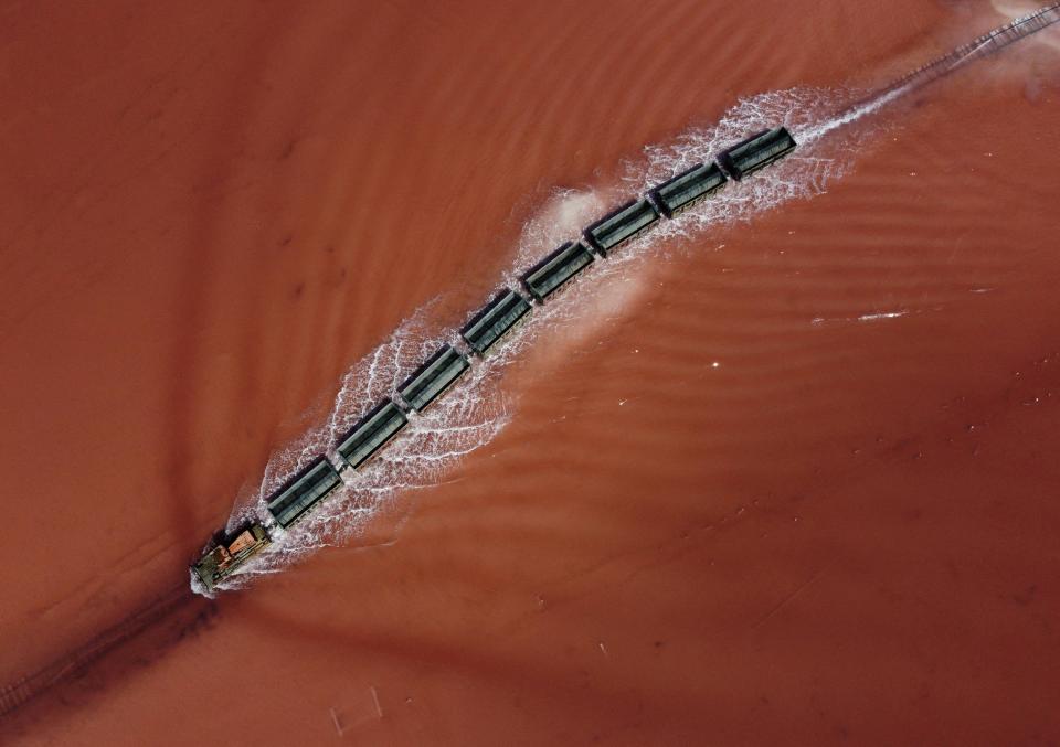 train drives across the bed of a drained area near the salt harvesting site of the Burlinskoye salt lake in the Altai Region, Russia July 20, 2022. REUTERS/Alexey Malgavko