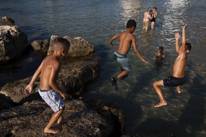 Israeli kids jump into the Mediterranean Sea in Tel Aviv's beach, Israel, Saturday, July 4, 2020. (AP Photo/Oded Balilty)