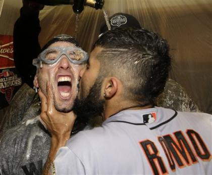 Sergio Romo kisses Marco Scutaro as they are sprayed with celebratory champagne. (AP)