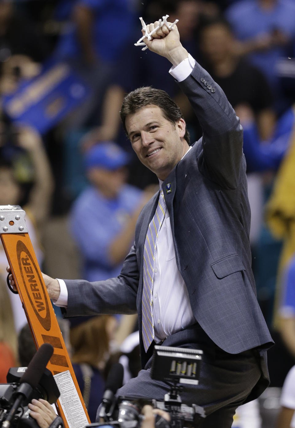UCLA coach Steve Alford holds up a piece of the net after his team defeated Arizona, 75-71, in the championship game of the NCAA Pac-12 conference college basketball tournament, Saturday, March 15, 2014, in Las Vegas. (AP Photo/Julie Jacobson)