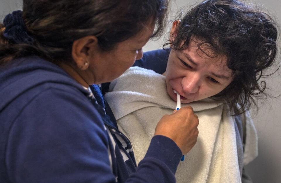 Rosa Andresen, left, brushes her daughter's teeth.