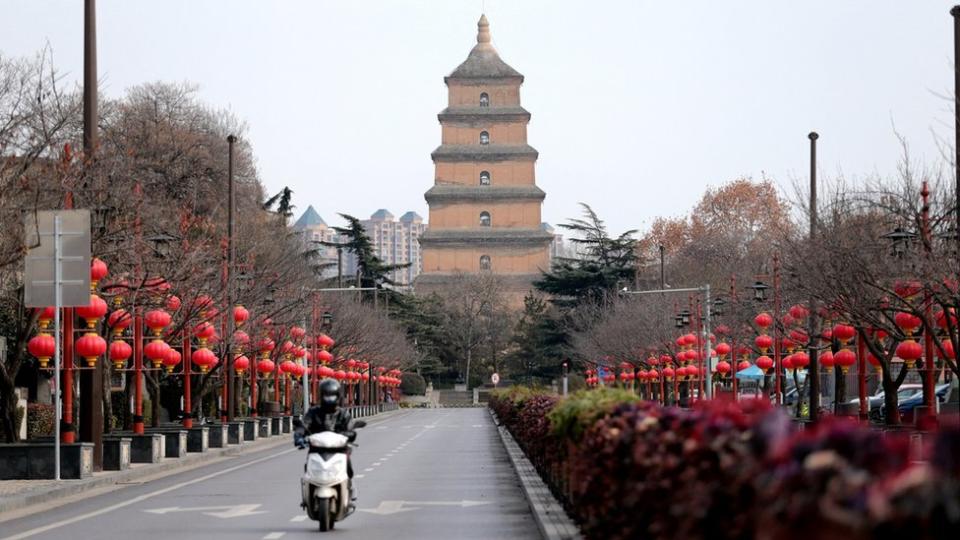 A citizen rides on a nearly-empty street after Xi'an imposed a citywide lockdown to halt the spread of COVID-19 epidemic on December 26, 2021 in Xi'an, Shaanxi Province of China