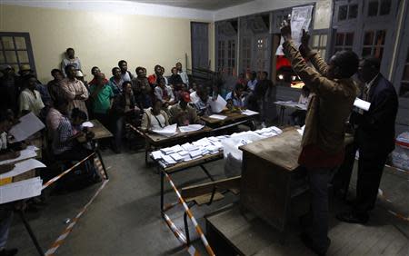 An official from Madagascar's Commission Electorale Nationale Independante pour la Transition (CENI-T) displays a ballot to agents as he counts votes at a polling centre in Madagascar's capital Antananarivo December 20, 2013. REUTERS/Thomas Mukoya