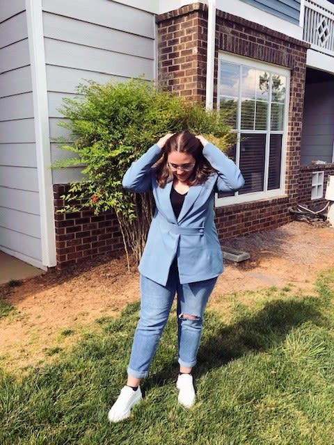 Woman outside posing in a blazer and jeans