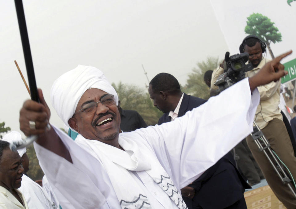 FILE - In this May 1, 2010 file photo, then Sudanese President Omar el-Bashir greets his supporters during a rally at a fair in Khartoum, Sudan. A Sudanese official and a former minister said Wednesday, April, 17, 2019, that the military has transferred ousted President Omar al-Bashir to the city's Kopar Prison in Khartoum. The move came after organizers of the street protests demanded the military move al-Bashir to an official prison. (AP Photo/Abd Raouf, File)