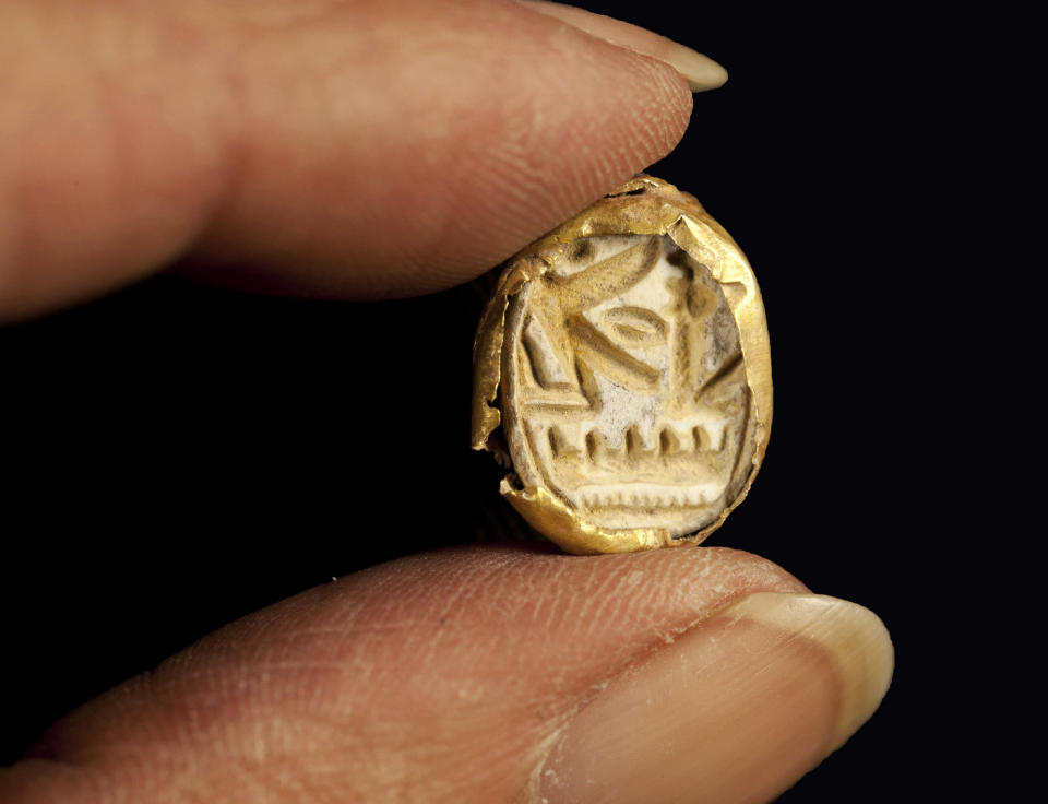This undated photo released by Israel’s Antiquities Authority shows a scarab seal ring encased in gold, carved with the name of Pharaoh Seti I, who ruled ancient Egypt in the 13th century BC, found at Tel Shadud, an archaeological mound in the Jezreel Valley. Israeli archaeologists have unearthed a rare sarcophagus featuring a slender face and a scarab ring inscribed with the name of an Egyptian pharaoh, Israel’s Antiquities Authority said Wednesday April 9, 2014. (AP Photo/Israel’s Antiquities Authority)