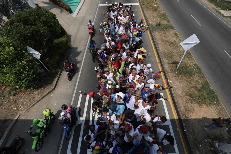 Venezuelans cheer as they ride atop a semi-trailer to the Simon Bolivar international bridge, accompanying U.S. humanitarian aid destined for Venezuela, in Cucuta, Colombia (AP)