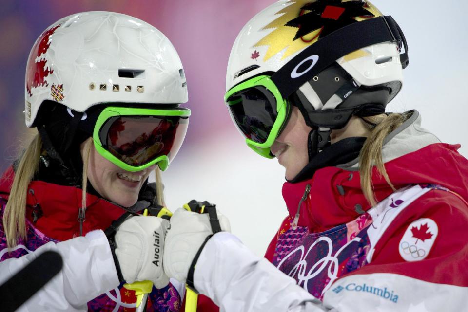 Canada's Justine Dufour-Lapointe, left, and Chloe Dufour-Lapointe bump fists as they are introduced for the women's moguls final at the Rosa Khutor Extreme Park, at the 2014 Sochio Winter Olympics, Saturday, Feb. 8, 2014, in Krasnaya Polyana, Russia. (AP Photo/The Canadian Press, Adrian Wyld)