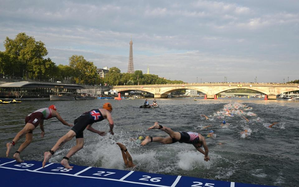 Athletes dive into the Seine during the Olympic test event in August 2023