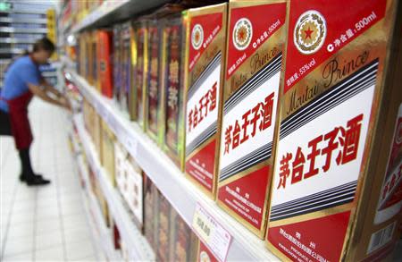 An employee arranges boxes of wine at a supermarket in Nantong, Jiangsu province, September 3, 2013. REUTERS/Stringer