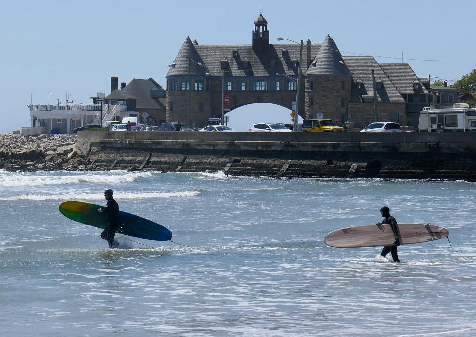 Surfers head out from Narragansett Town Beach in search of waves in May 2020.