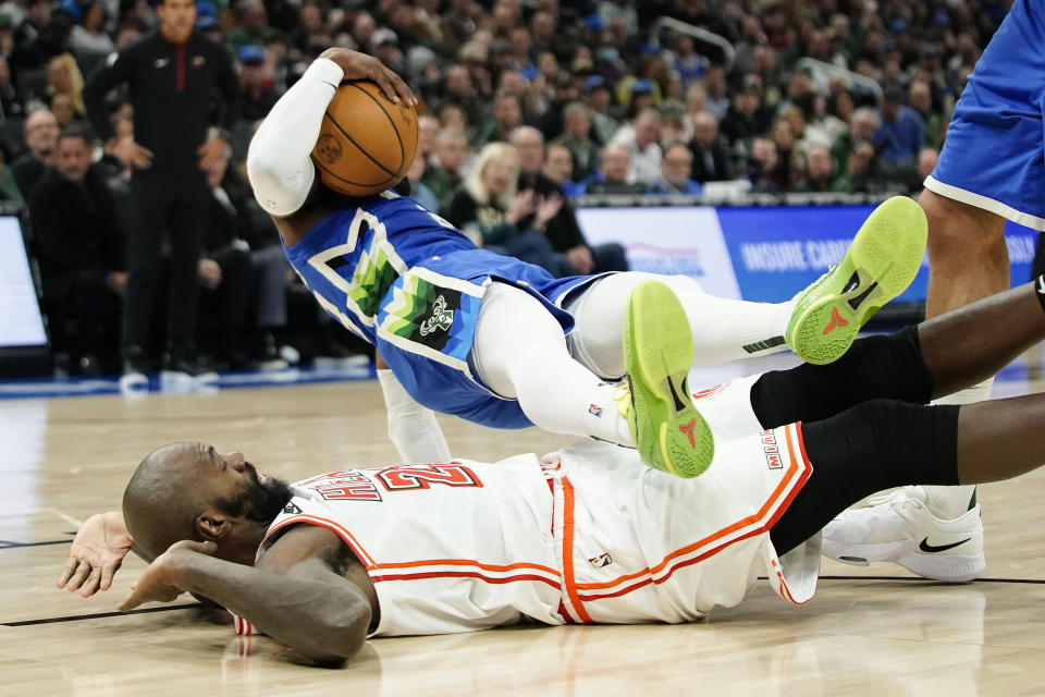 Milwaukee Bucks' Wesley Matthews, top, falls over Miami Heat's Dewayne Dedmon, bottom, after being fouled during the first half of an NBA basketball game Saturday, Feb. 4, 2023, in Milwaukee. (AP Photo/Aaron Gash)