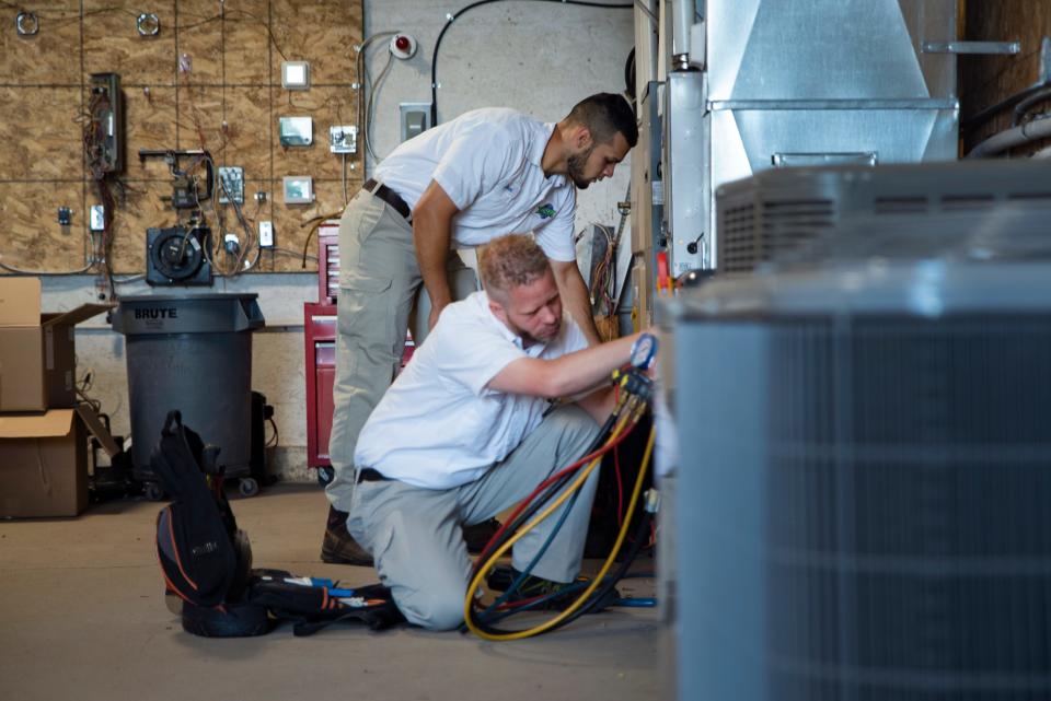 Joe Anderson and Jared Linderman adjust HVAC and furnace electrical components during a regular training session at Schaal Plumbing, Heating and Cooling.