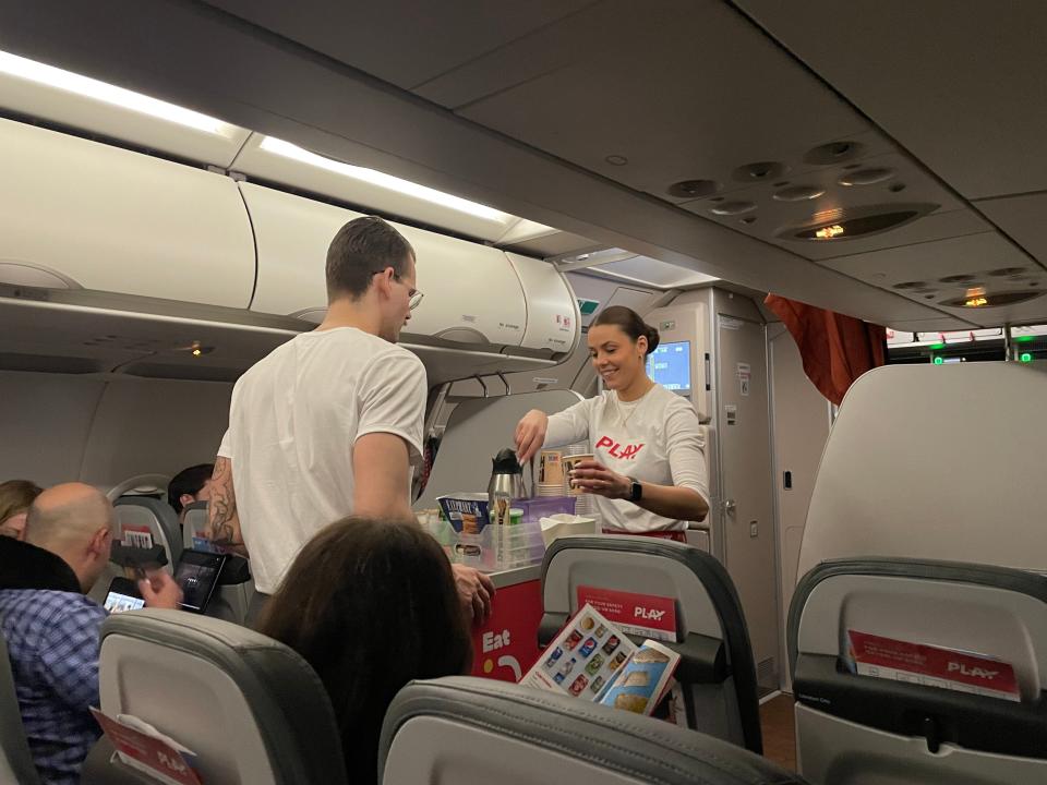 PLAY Airlines staff members doing in-flight service aboard flight Asia London Palomba PLAY Airlines review