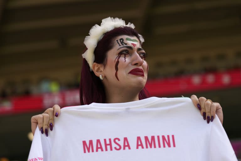 Una mujer iraní entró al campo de juego para protestar con una remera de la joven de 22 años que murió tras ser detenida por la policia de la moral (AP Photo/Alessandra Tarantino)