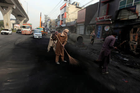 Workers clean a road a day after the Tehrik-e-Labaik Pakistan Islamist political party called off nationwide protests in Islamabad, Pakistan November 28, 2017. REUTERS/Faisal Mahmood