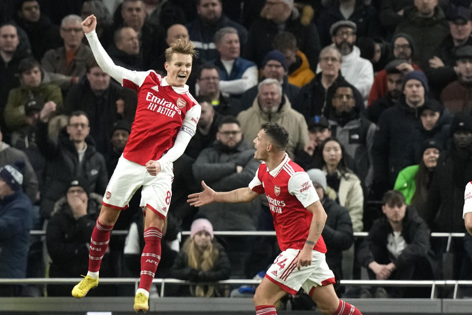 Arsenal's Martin Odegaard, left, celebrates with Arsenal's Granit Xhaka after scoring his side's second goal during the English Premier League soccer match between Tottenham Hotspur and Arsenal at the Tottenham Hotspur Stadium in London, England, Sunday, Jan. 15, 2023. (AP Photo/Frank Augstein)