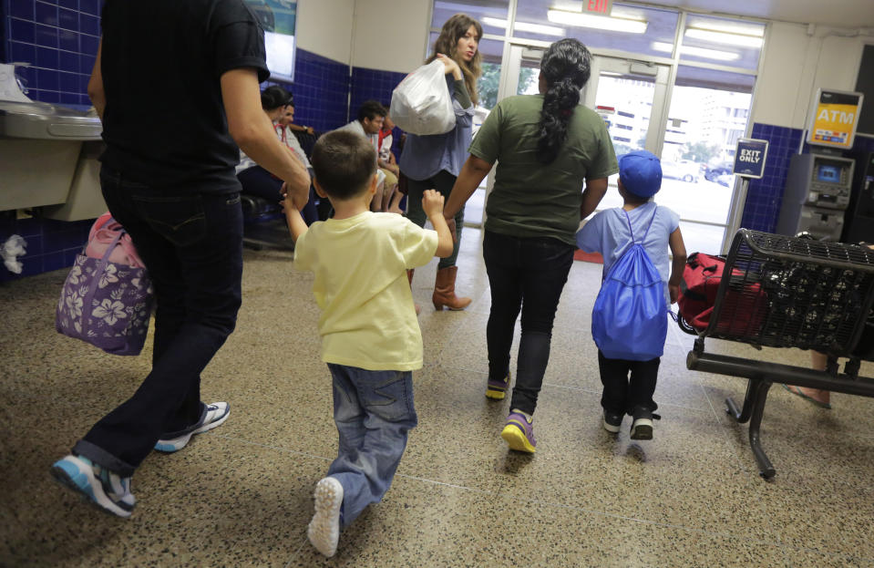 ARCHIVO - En esta imagen de archivo del 7 de julio de 2015, migrantes de El Salvador que entraron en el país sin permiso de residencia caminan hacia un autobús tras recibir autorización para salir de un centro de detención familiar en San Antonio, Texas. (AP Foto/Eric Gay, Archivo)