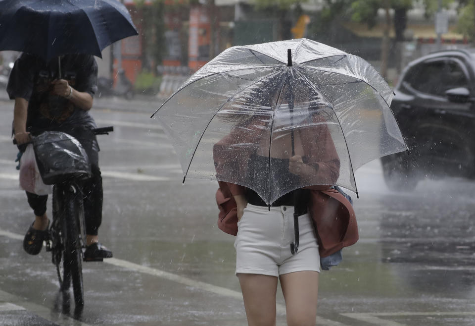 A woman struggles with her umbrella against powerful gusts of wind generated by Typhoon Chanthu in Taipei, Taiwan, Sunday, Sept. 12, 2021. Typhoon Chanthu drenched Taiwan with heavy rain Sunday as the storm’s center passed the island’s east coast heading for Shanghai. (AP Photo/Chiang Ying-ying)