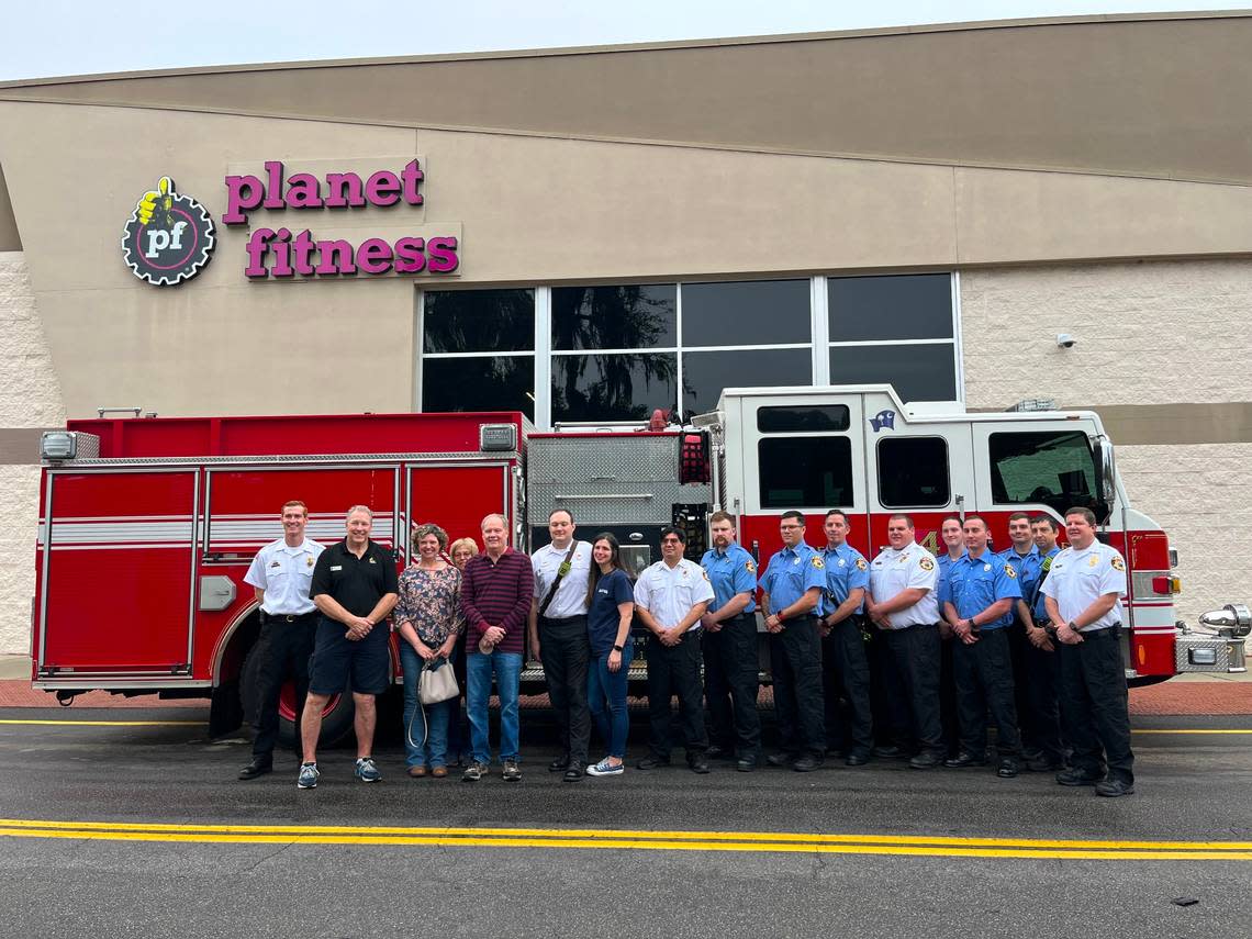 Firefighters and first responders from the City of Beaufort/Town of Port Royal Fire Department posed with Mike Kirby and his family Tuesday in front of the gym where they saved Kirby earlier this month.