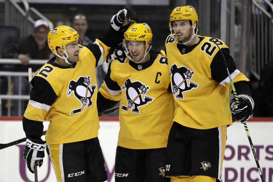 Pittsburgh Penguins' Sidney Crosby (87) celebrates his goal with Dominik Simon (12), and Marcus Pettersson (28) during the second period of the team's NHL hockey game against the Detroit Red Wings in Pittsburgh, Sunday, Feb. 16, 2020. (AP Photo/Gene J. Puskar)