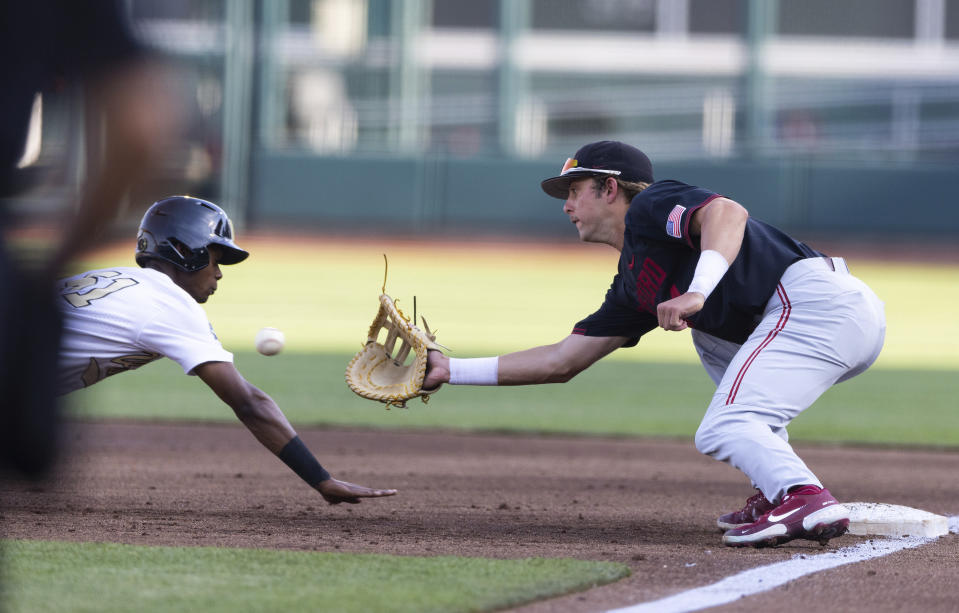 Stanford's Nick Brueser (24), right, tags out Vanderbilt's Enrique Bradfield Jr (51) on a dive back to first base in the first inning during a baseball game in the College World Series Wednesday, June 23, 2021, at TD Ameritrade Park in Omaha, Neb. (AP Photo/Rebecca S. Gratz)