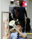 A station attendant makes an announcement about the resumption of shinkansen bullet train services at Tokyo station on June 30, 2015 after service was disrupted due to an apparent suicide attempt on board a moving train