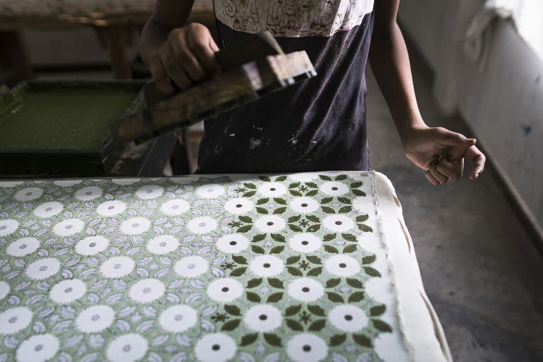 Un trabajador utiliza la técnica de estampado manual sobre una tela de algodón.