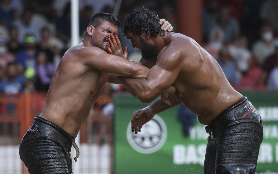 Wrestlers Ismail Koc, right, and Faruk Akkoyun compete during the semi-final of the 660th instalment of the annual Historic Kirkpinar Oil Wrestling championship, in Edirne, northwestern Turkey, Sunday, July 11, 2021.Thousands of Turkish wrestling fans flocked to the country's Greek border province to watch the championship of the sport that dates to the 14th century, after last year's contest was cancelled due to the coronavirus pandemic. The festival, one of the world's oldest wrestling events, was listed as an intangible cultural heritage event by UNESCO in 2010. (AP Photo/Emrah Gurel)