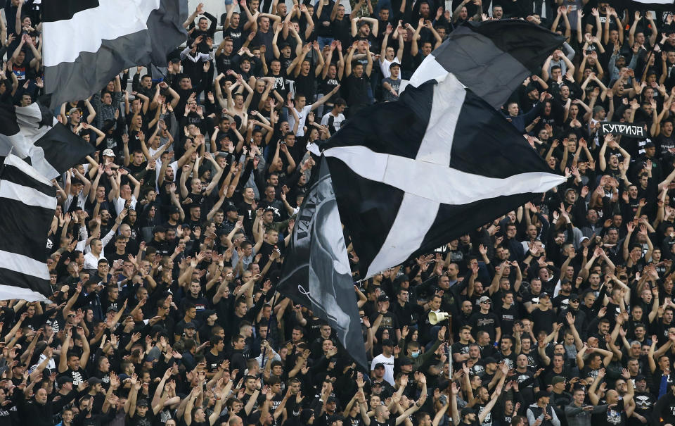 FILE - In this Wednesday, June 10, 2020 file photo, Partizan fans support their team prior a Serbian National Cup semifinal soccer match between Partizan and Red Star in Belgrade, Serbia. Serbia's president Aleksandar Vucic has cancelled his party's pre-election rallies and officials in Bosnia, Macedonia and Albania are appealing on citizens to respect protection measures after relaxation of rules against the new coronavirus led to a recent spike in cases in the Balkan countries. (AP Photo/Darko Vojinovic, File)