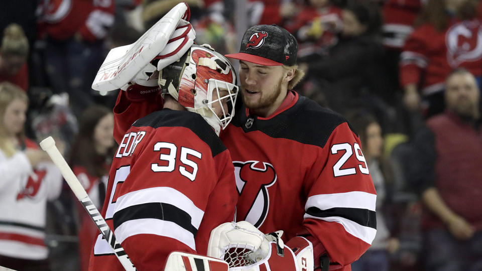 New Jersey Devils goaltender Cory Schneider (35) and goaltender MacKenzie Blackwood (29) celebrate after defeating the Buffalo Sabres 3-1 during an NHL hockey game, Monday, March 25, 2019, in Newark, N.J. (AP Photo/Julio Cortez)