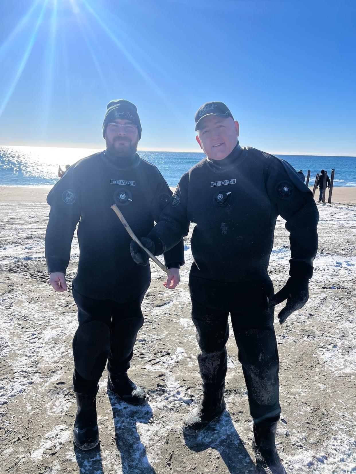 Trevor Croft, left and Shawn Bath of the Clean Harbour Initiative helped secure the shipwreck found at Cape Ray. In this photo, Bath is holding a copper pipe that was taken from the vessel. (Submitted by Trevor Croft - image credit)