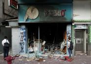 A man inspects a Bestmart store which was vandalised during Sunday's anti-government protest in Hong Kong