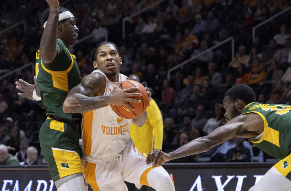 Tennessee guard Zakai Zeigler (5) drives between Norfolk State's Christian Ings and Jack Doumbia, right, during the first half of an NCAA college basketball game Tuesday, Jan. 2, 2024, in Knoxville, Tenn. (AP Photo/Wade Payne)