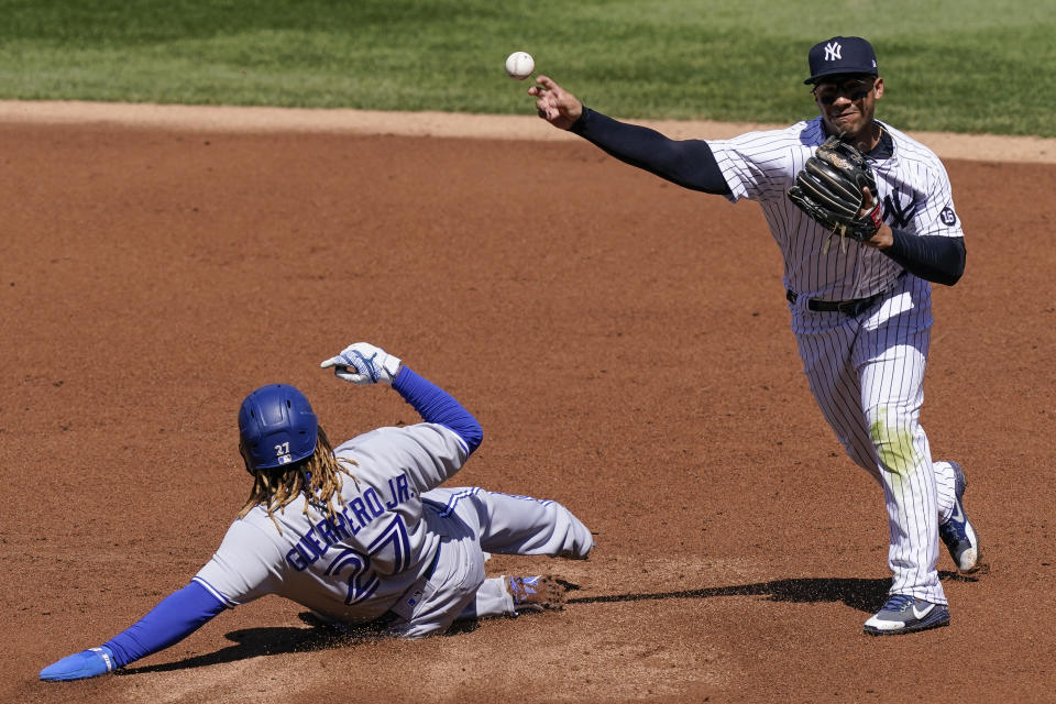 New York Yankees shortstop Gleyber Torres, right, forces out Toronto Blue Jays' Vladimir Guerrero Jr. (27) at second before throwing to first to complete a double play in the second inning of a baseball game, Saturday, April 3, 2021, in New York. Toronto Blue Jays' Lourdes Gurriel Jr. was out at first. (AP Photo/John Minchillo)