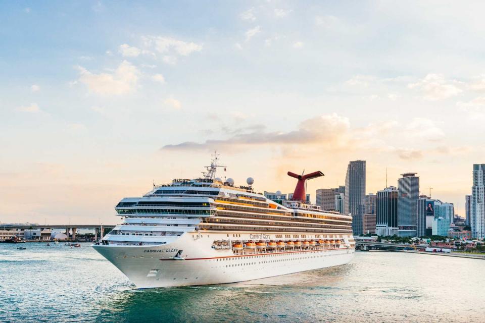 A large passenger cruise ship, the Carnival Glory, turns around in Biscayne Bay as it prepares to exit the downtown Port of Miami