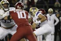 Washington running back Wayne Taulapapa, right, carries the ball during the first half of an NCAA college football game against Washington State, Saturday, Nov. 26, 2022, in Pullman, Wash. (AP Photo/Young Kwak)