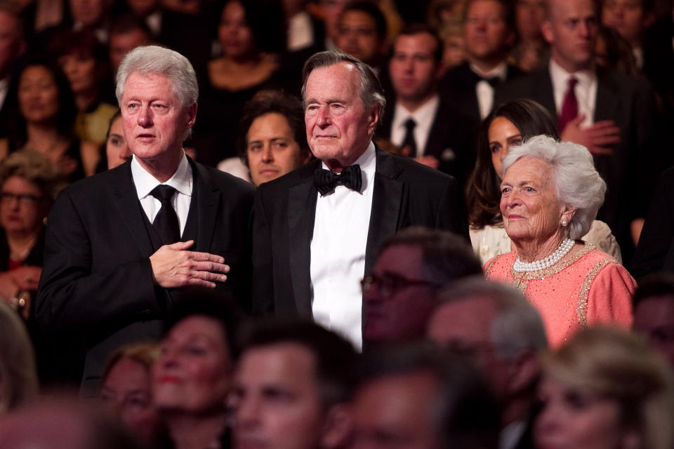 Former President Bill Clinton (left), former President George H.W. Bush and Barbara Bush stand for the National Anthem at the Points of Light Institute Tribute to George H.W. Bush at the John F. Kennedy Center for Performing Arts on March 21, 2011, in Washington, D.C.