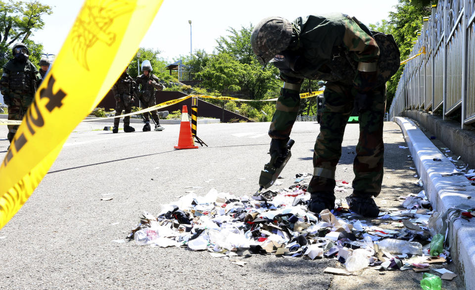 South Korean soldier wearing protective gears checks the trash from a balloon presumably sent by North Korea, in Incheon, South Korea, Sunday, June 2, 2024. South Korea said Sunday it’ll take strong retaliatory steps against North Korea over its launch of trash-carrying balloons and other provocations on South Korea.(Im Sun-suk/Yonhap via AP)